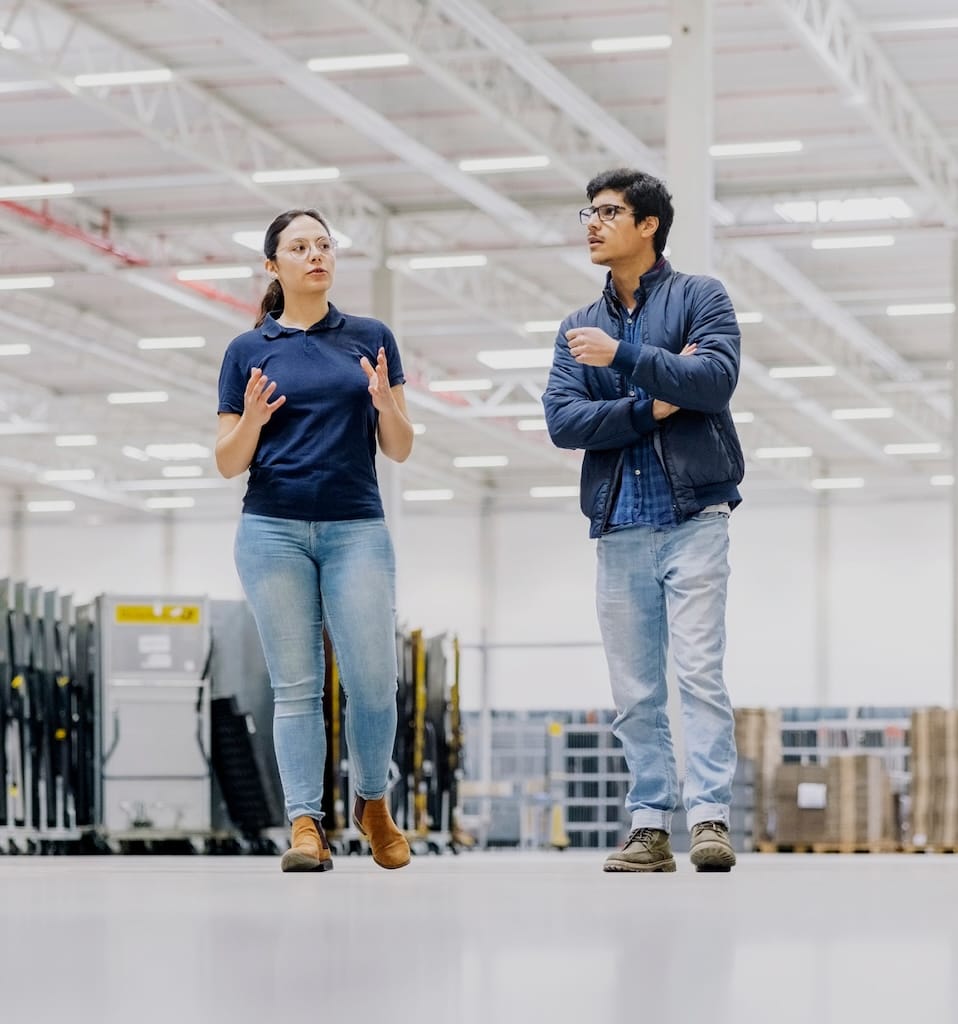 2 people walking in a warehouse