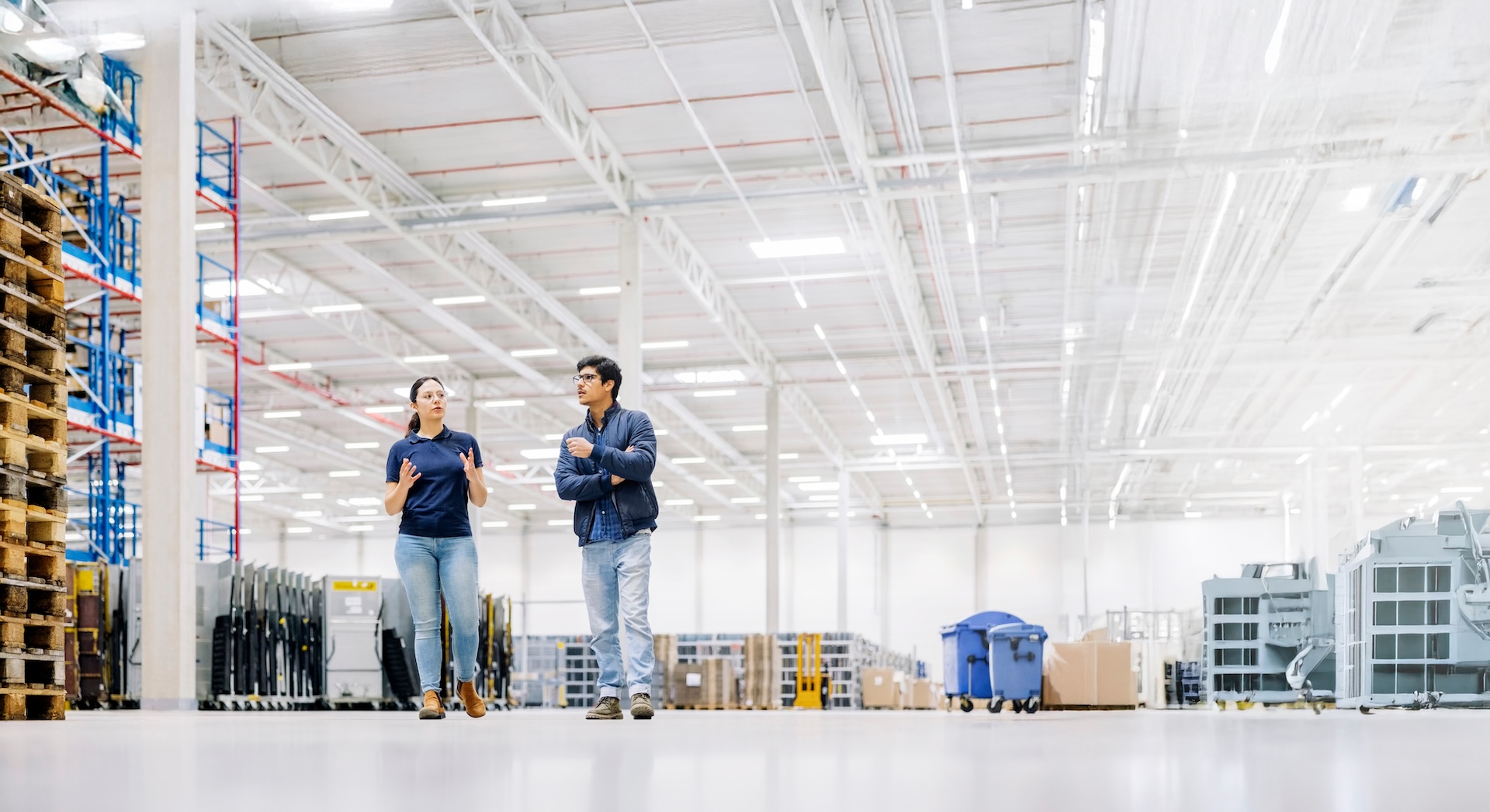 2 people walking in a warehouse